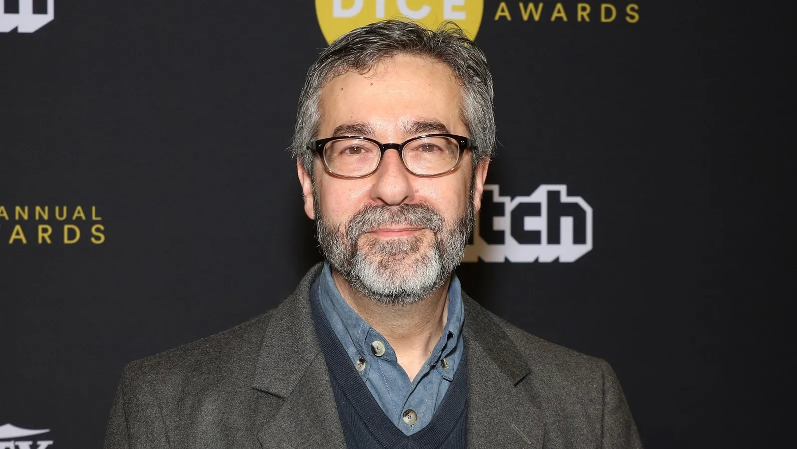 Warren Spector portrait at a 2015 video game industry event, smiling at the camera in a black collared shirt