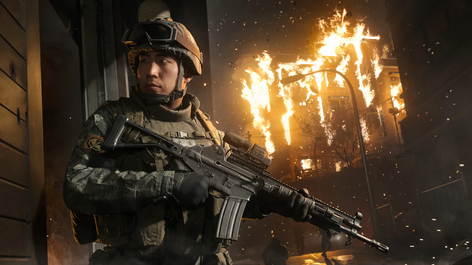 Modern Warfare 4 official screenshot of a soldier advancing through a dark combat zone with a burning building in the background.