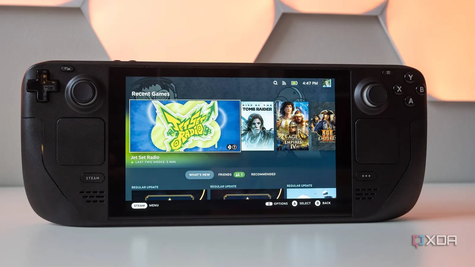 A Steam Deck LCD sitting on a desk with the SteamOS menu on screen