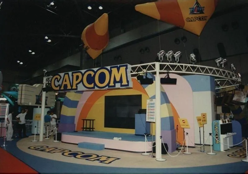 Capcom booth with a stage and hanging banners at the first Tokyo Game Show in 1996