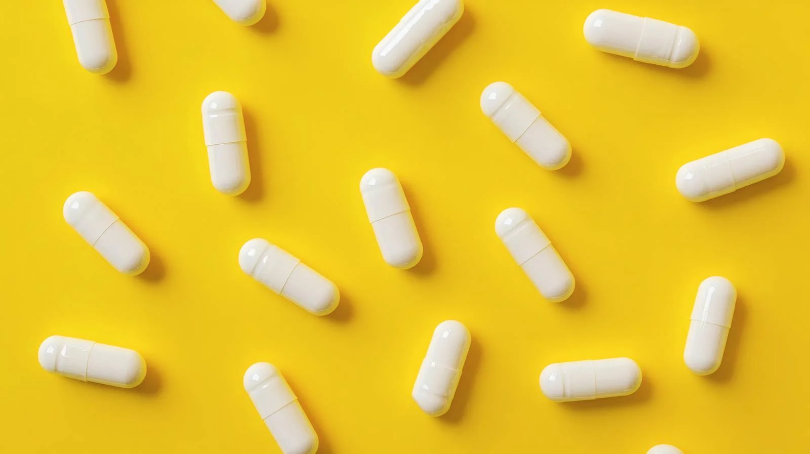 White Capsules on Bright Yellow Background — free download from Dotvec