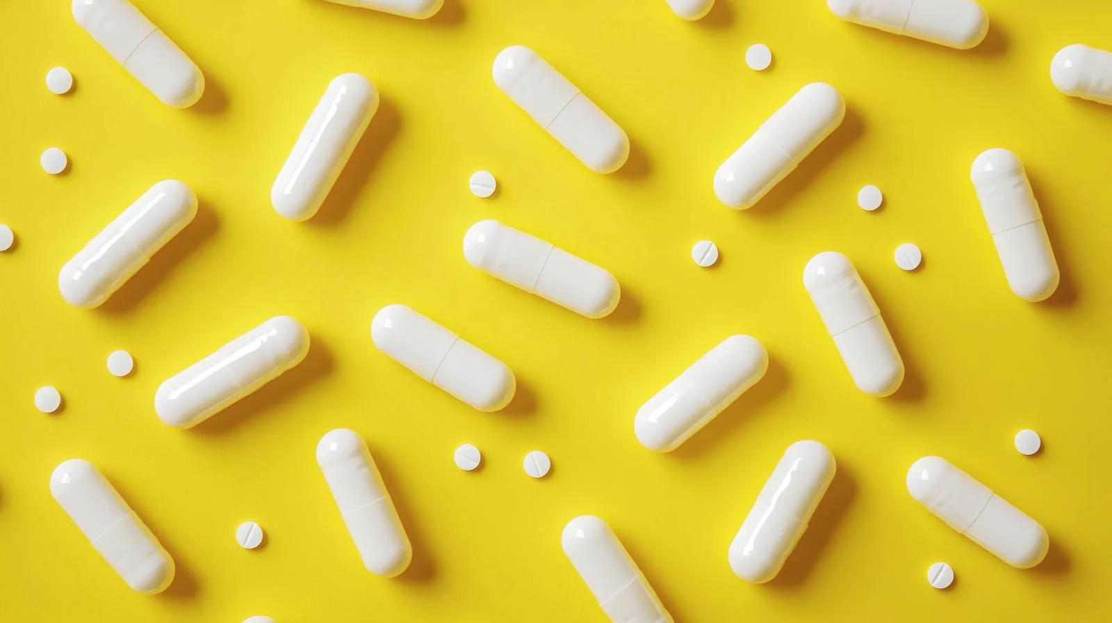 Medicine Capsules on Bright Yellow Background — free download from Dotvec