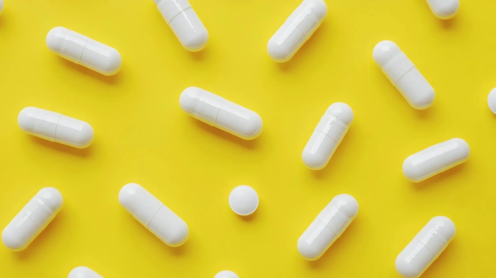 White Capsules on Yellow Background Isolated — free download from Dotvec