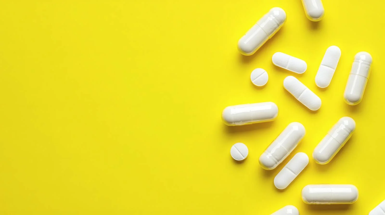 Pure White Supplement Capsules on Yellow — free download from Dotvec