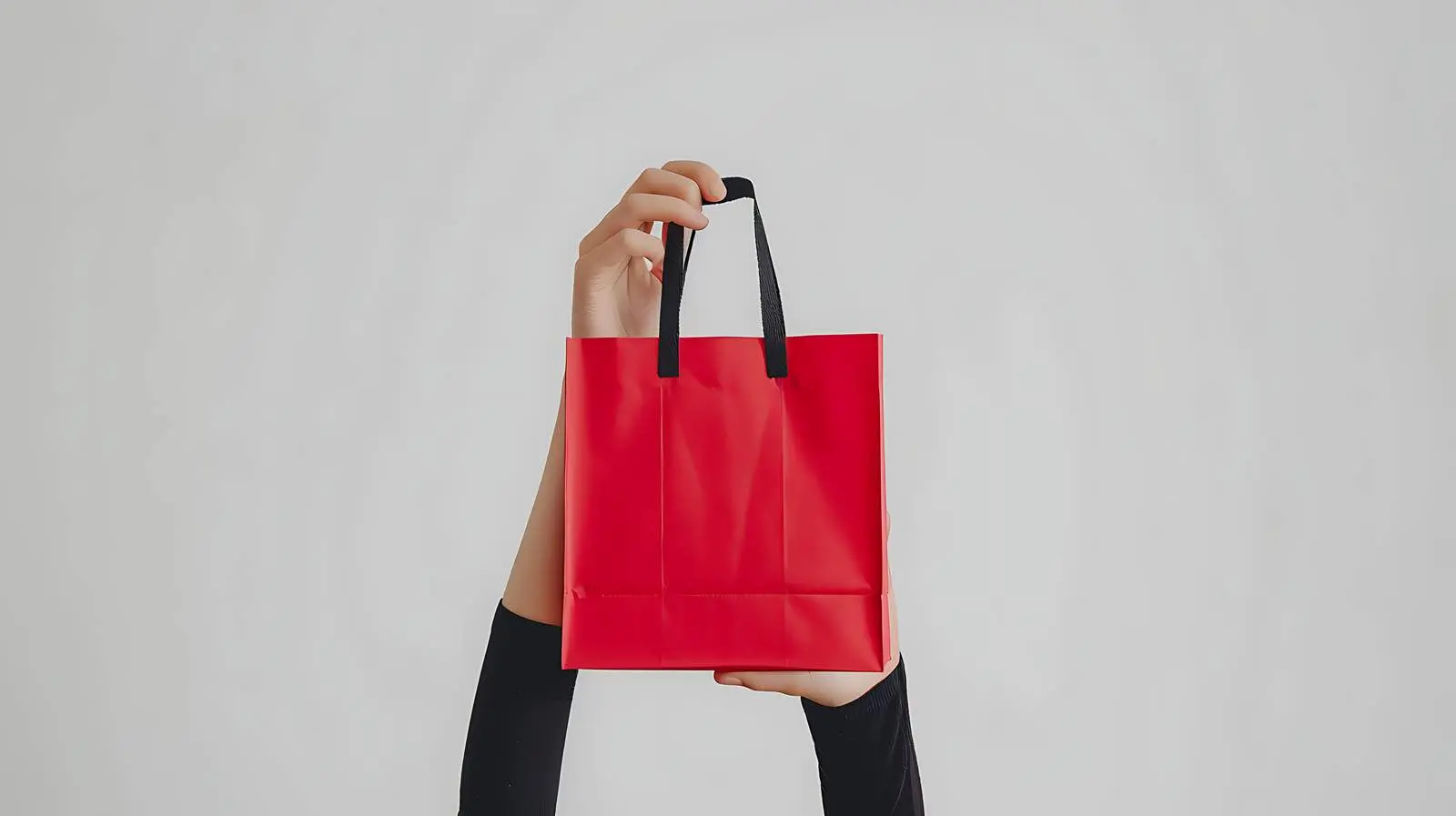 Hand Holding Red Shopping Bag with Sale Sign – free savings image from Dotvec