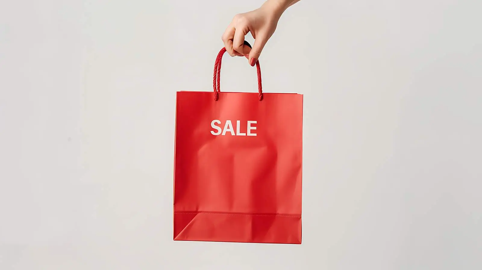 Hand Holding Red Craft Shopping Bag with Sale Sign – free gift bag image from Dotvec