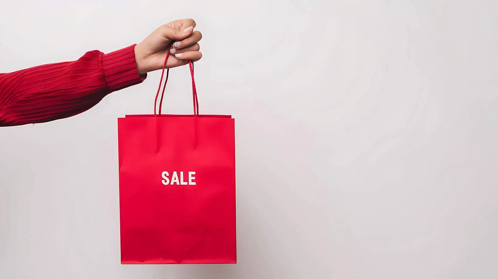 Hand Holding Red Craft Shopping Bag with Sale Sign – free gift bag image from Dotvec