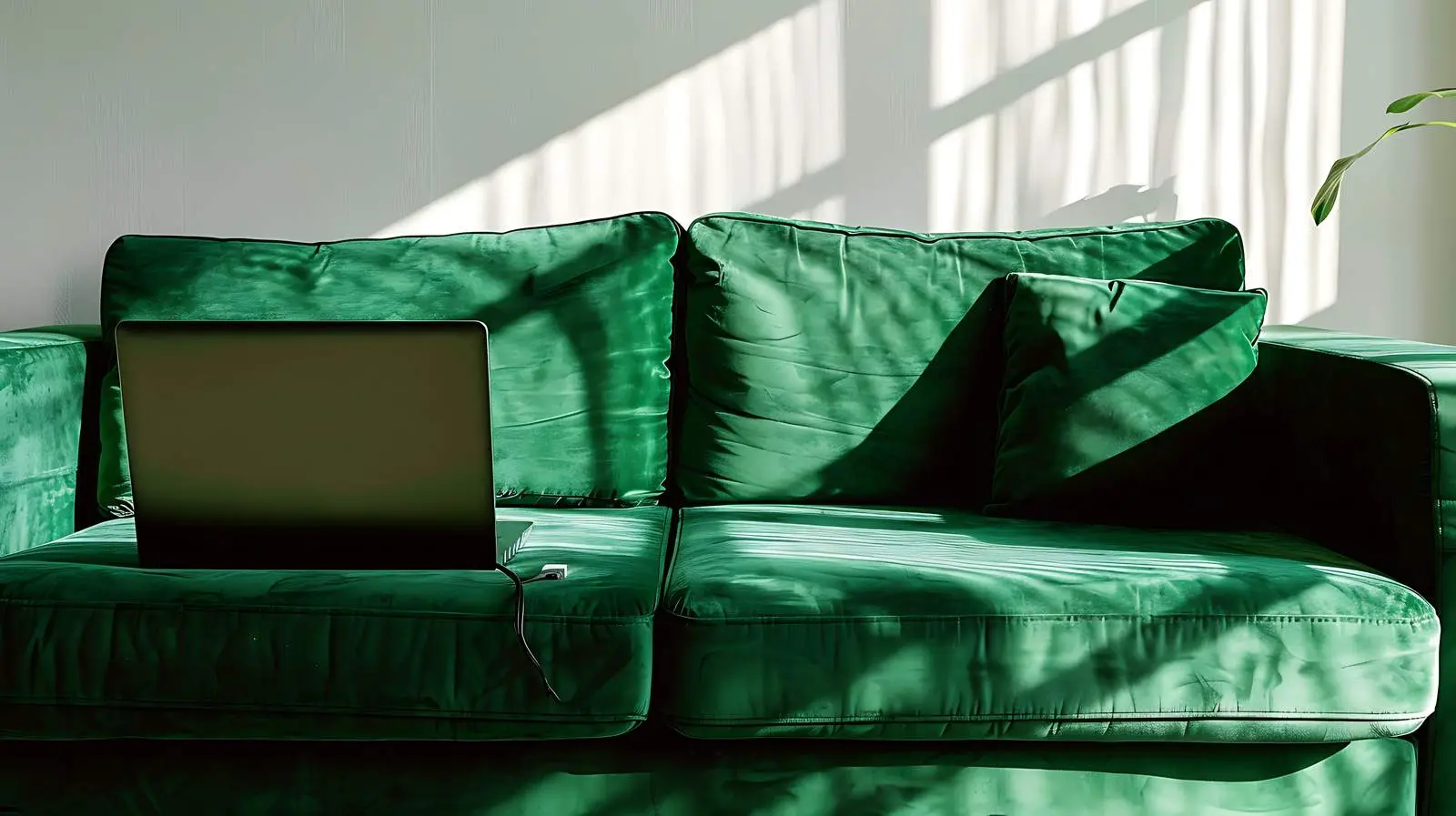 Laptop on Green Sofa with Sunlight Shadows — free download from Dotvec