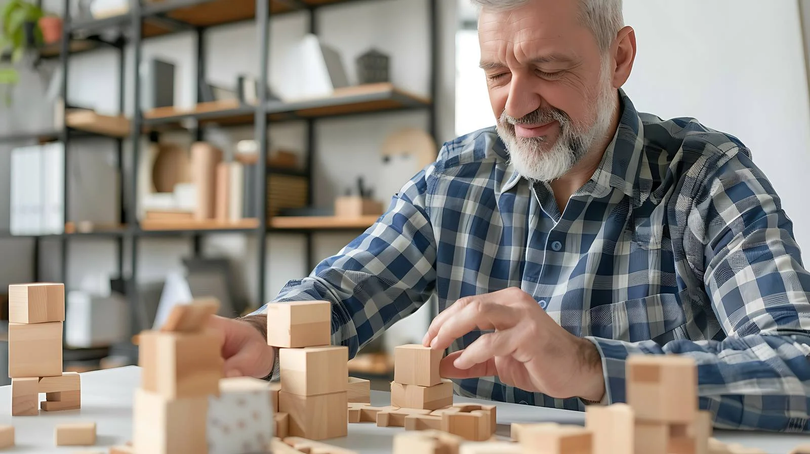 Senior man assembling wooden cube in office — free download from Dotvec