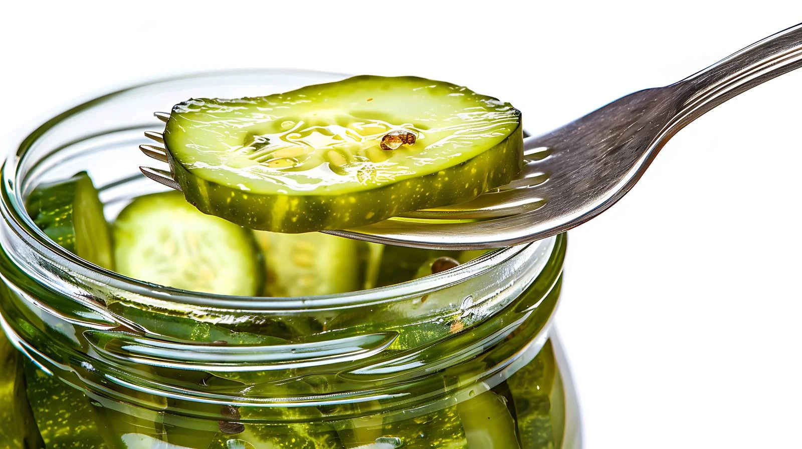Elevated Pickled Cucumber on Fork with Jar Background — free download from Dotvec