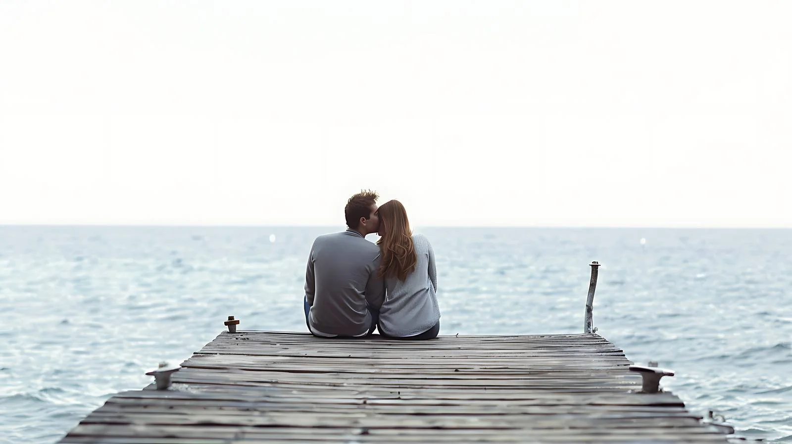 Serene couple on pier overlooking sea — free download from Dotvec