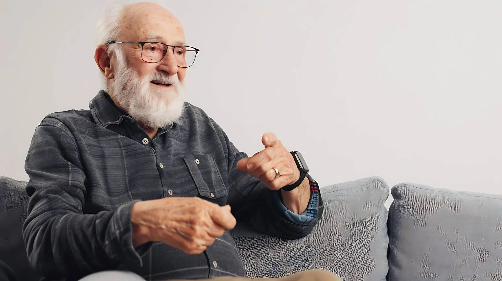 Elderly gentleman on sofa using smartwatch — free download from Dotvec