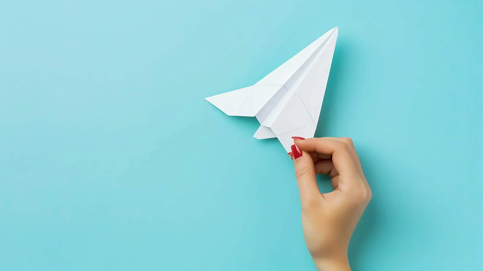 Woman Holding Paper Plane on Pale Blue Background – free enjoyment image from Dotvec