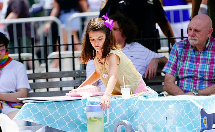 Suri Cruise rouba a cena na Parada Gay de Nova York vendendo limonada… Entenda!