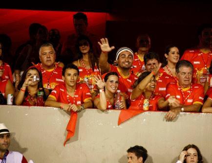 Thiago Lacerda e a mulher, Vanessa Lóes, que espera uma filha dele, mal chegaram ao camarote da Brahma, na Sapucaí, e já penduraram no braço um cadarço vermelho da Nike, que faz parte da campanha RED, em parceria com Bono