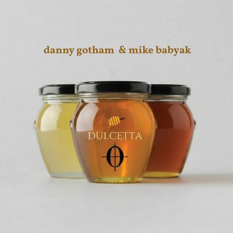Three overlapping honey jars of different hues, one in front two on either side of it. The middle jar's label has a drawing of a honey dipper above the word "DULCETTA" which in turn stands over a coda musical sign. Above the jars reads Danny Gotham and Mike Babyak. The words Coming June 30th scroll across the image.