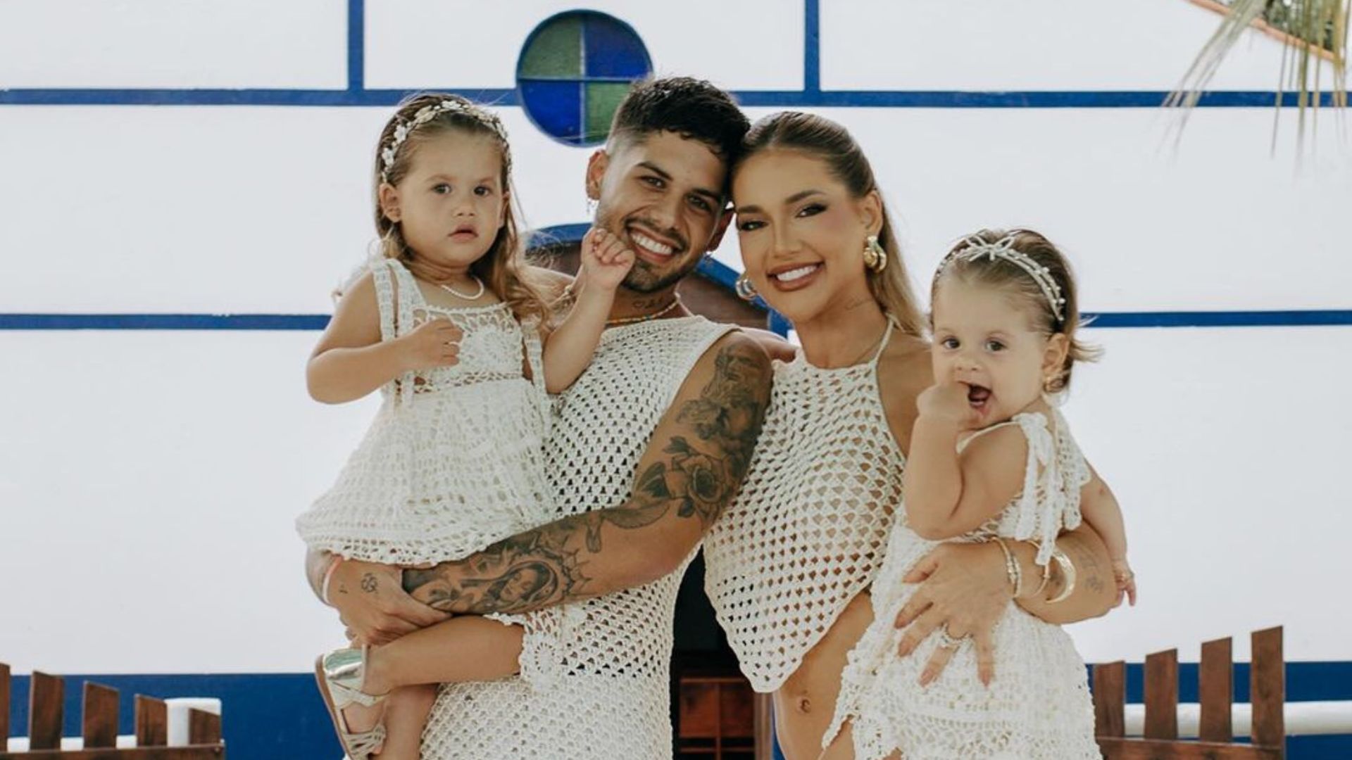 Fam&iacute;lia com m&atilde;e, pai e duas filhas posando para foto