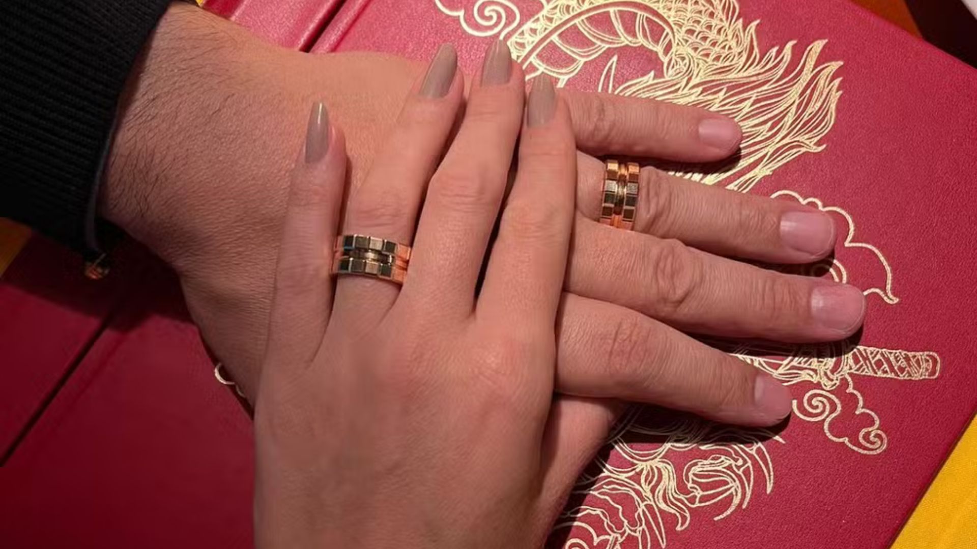 Mão de casal com alianças de outro