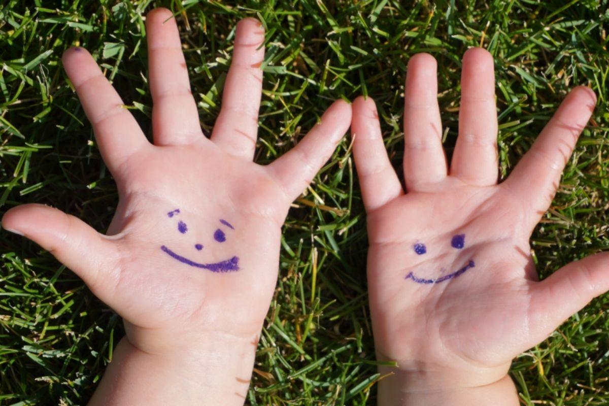 Mãos com sorrisos desenhados