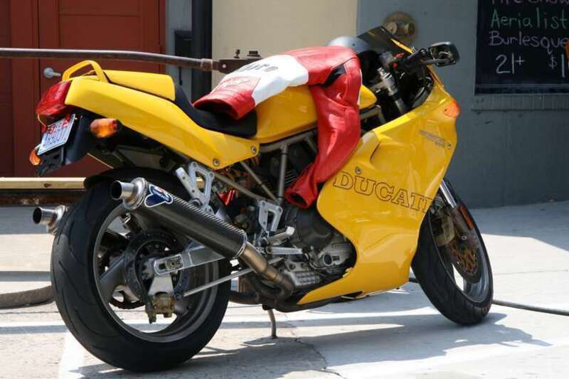 A yellow Ducati 900 SuperSport parked outside Motorco Music Hall in Durham, North Carolina.
