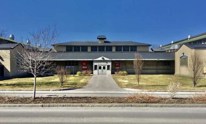 As seen in March 2021, the main façade of the Cattle Building on the New York State Fairgrounds, as seen from the back end of the Science &amp; Industry Building. Eschewing the High Neoclassical style employed by the Buffalo firm of Green &amp; Wicks