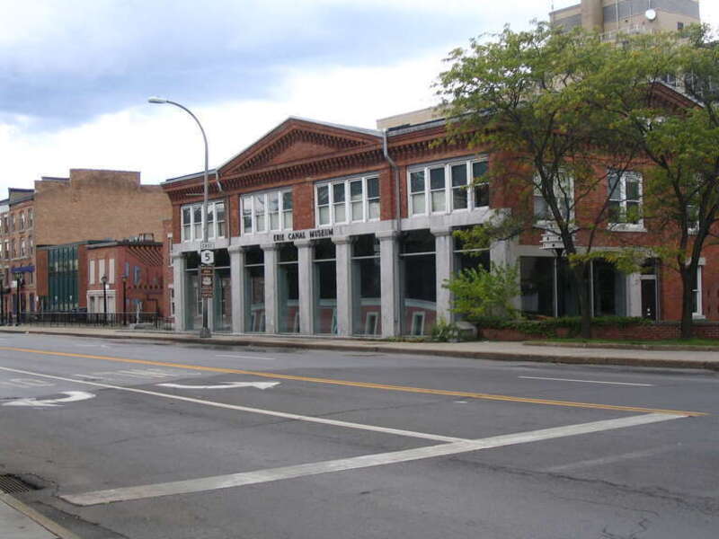 Erie Canal Museum in Syracuse, NY. Former weighlock bulding, built in 1850. The picture is taken from the same place as an old photograph showing the canal instead of the street.
