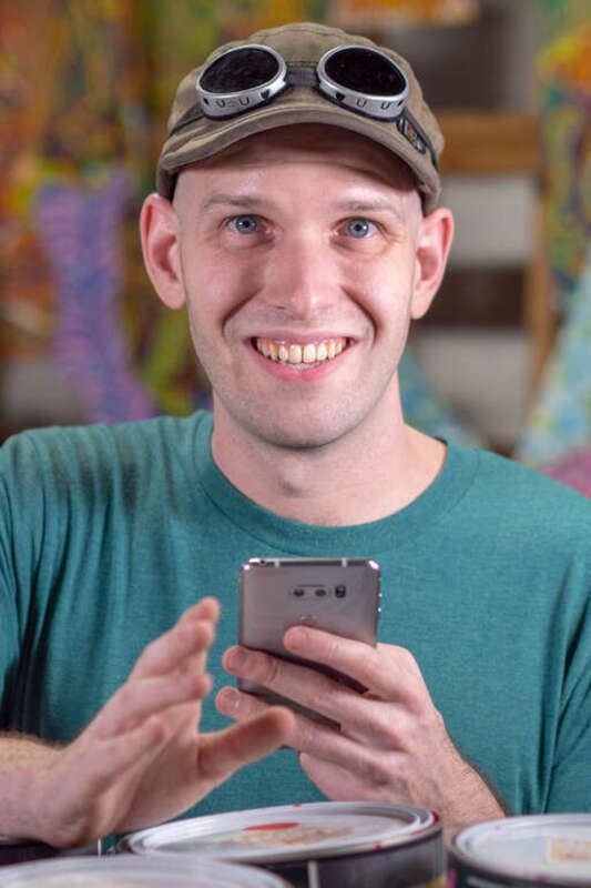 Foo Conner on his phone at the Randyland Studio.