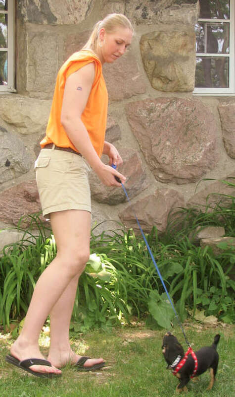 Katie Feenstra walking a dog at the Detroit Shock's "Be Fit" picnic.