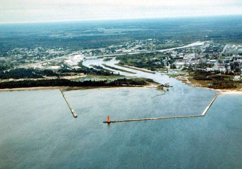 Aerial view of Manistique, Michigan, USA. The city lies on the northern shore of Lake Michigan in the Upper Peninsula of Michigan. The Manistique River flows through the town and into Lake Michigan through the harbor.