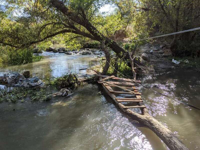 The confluence of the combined flow of Lower Silver Creek and Miguelita Creek, aka Lower Silver Creek, (from far center) merges with the the flow of Coyote Creek (from the right) here by Watson Park, San José, California.  A makeshift footbridge