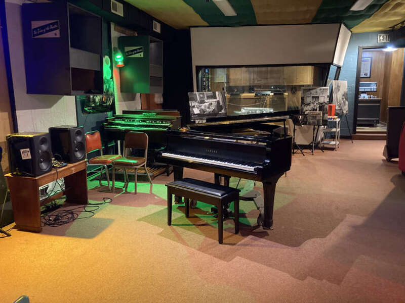 The photo shows the interior of Muscle Shoals Sound Studio with various instruments.
