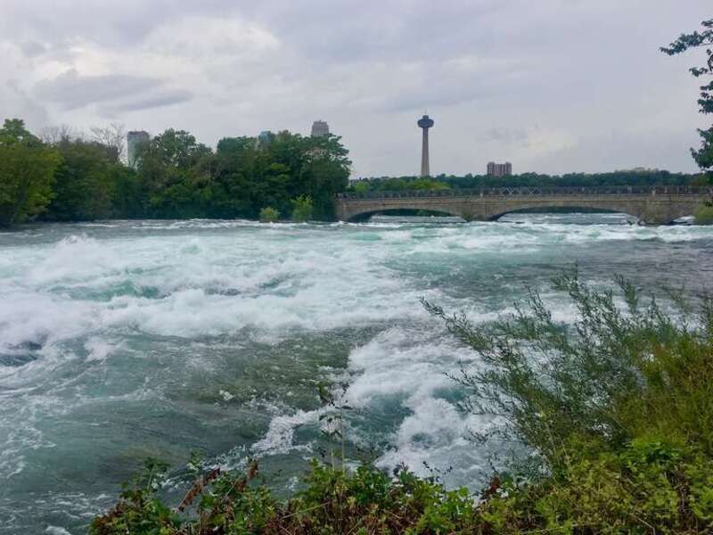The roiling rapids of the Niagara River just upstream from the falls, as seen from the Shoreline Trail in Niagara Falls State Park, New York. This stretch of the river is known as "Hell's Half Acre", for obvious reasons. The view is southwest toward