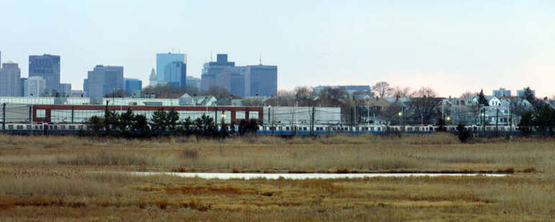 Orient Heights Yard with old 0600 Blue Line stock, with the Boston skyline behind. Taken from Belle Isle Marsh.