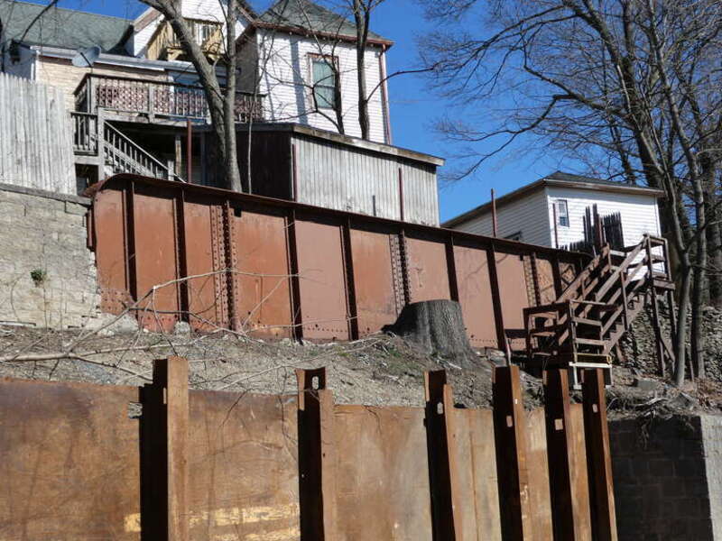 Part of a bridge deck - reputably from the nearby Charles River Branch - reused as a retaining wall in Newton Highlands, seen in March 2022