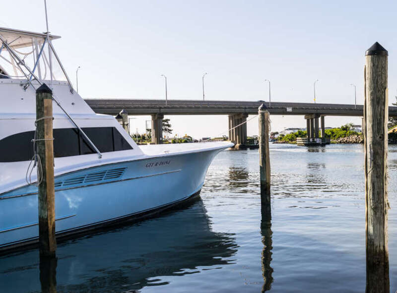 Rudee Inlet Bridge and boats at the Virginia Beach Fishing Center. The boat on the left is named "GIT*R*DONE".