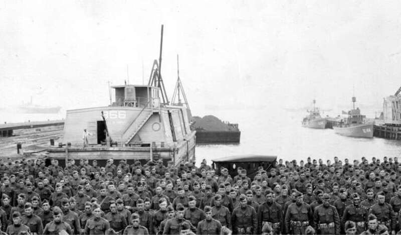 In formation at Newport News, Virginia, after arriving from Europe on USS Artemis (ID2187) on 26 June 1919. U.S. Army barge No. 856 is in the left background, with a loaded coal barge astern. U.S. Navy Submarine Chasers SC-413 and SC-414 are