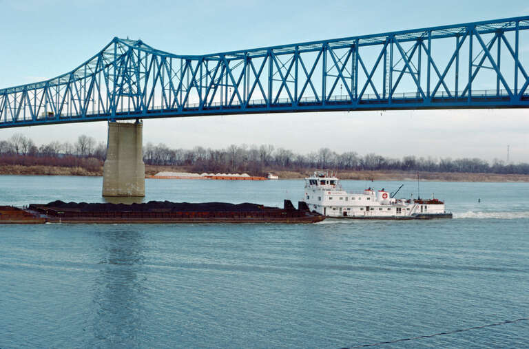 Looking NNE from Kentucky bank.
Towboat "Olmstead" (doc. # 624201) downbound at Glover Cary Bridge (opened to traffic in 1940).
Ohio River mile 756.
Owensboro, Kentucky.
Dec. 1987.
File # 87l032.
.
"Olmstead" was built in 1980 by St. Louis Ship and