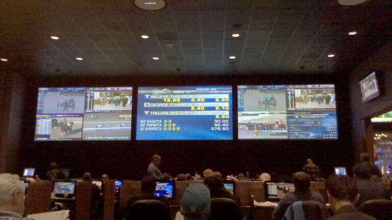 Dover Downs' sports lounge, showing the three main TV which are simulcasting different horse racing tracks