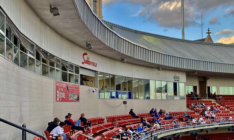A view of the upper deck and press box at Sahlen Field during a September 2021 game between the Buffalo Bisons and the Syracuse Mets. The "RER" monogram above the press box windows at far right refers to former Bisons team owner Robert E. Rich Sr.,
