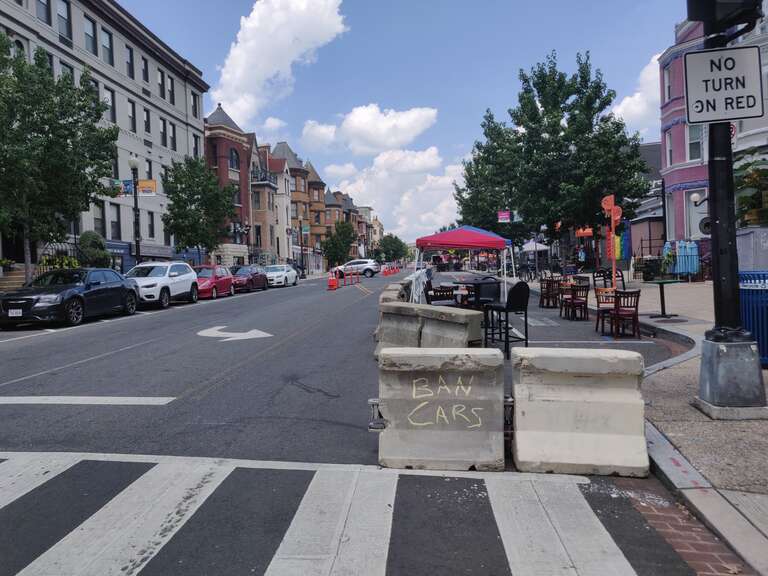 Barricades create a pedestrian zone on 18th Street Northwest in the Adams Morgan neighborhood of Washington, D.C., to give extra space to restaurants for outdoor seating during the COVID-19 pandemic. Graffiti reading "ban cars" adorns one block.