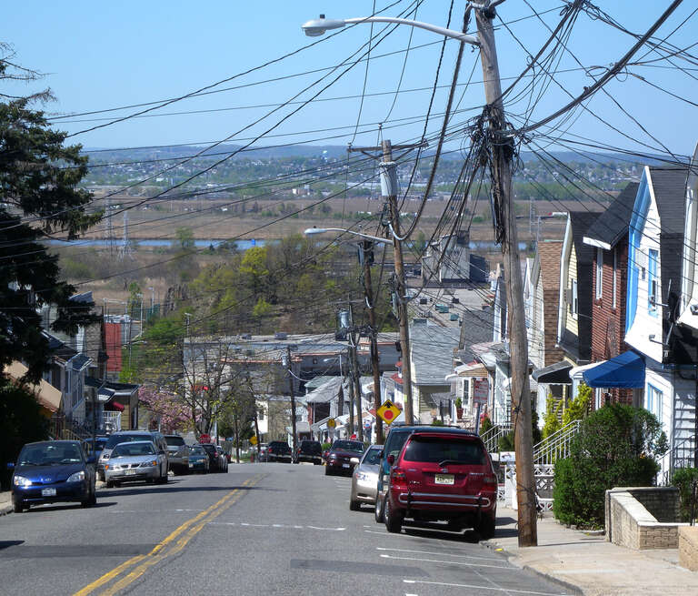 Looking northwest down a steep residental street in the lower 80s on a sunny midday.