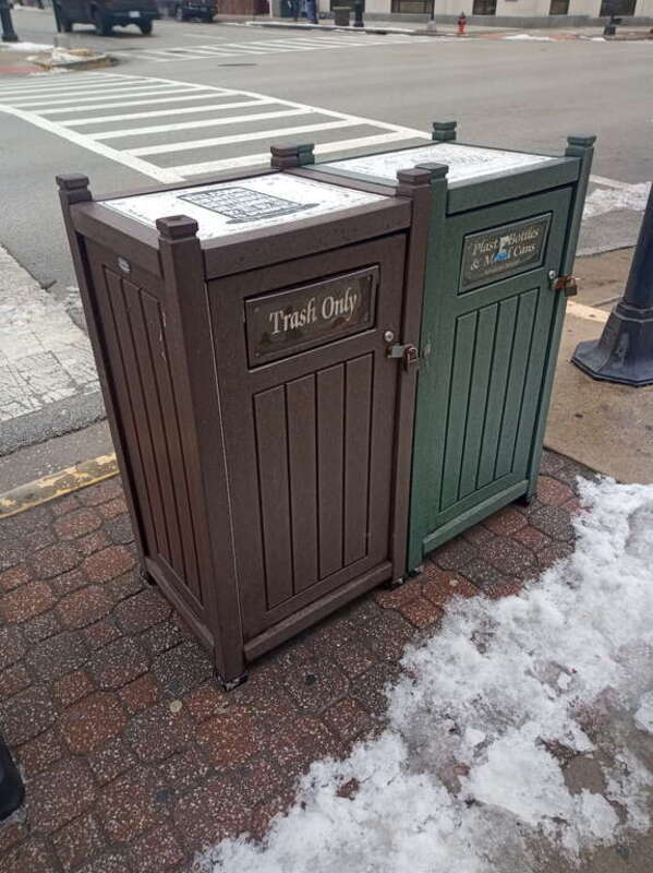 Gray plastic waste container divided between "trash only" and "plastic bottles and metal cans" in downtown Springfield, Illinois.