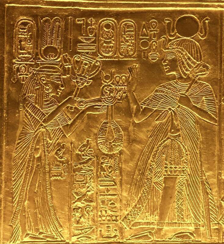Scene from gilded shrine of Tutankhamen showing him and his wife Queen Ankhesenamun. Queen hols a sistrum and menat.