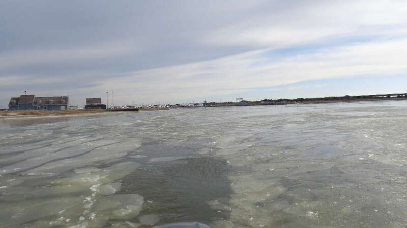 Cold weather ahead of the storm causes icy conditions in Oregon Inlet and hampers efforts to shore up the bridge against scour.