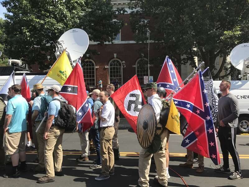 Alt-right members preparing to enter Emancipation Park holding Nazi, Confederate, and Gadsden "Don't Tread on Me" flags.