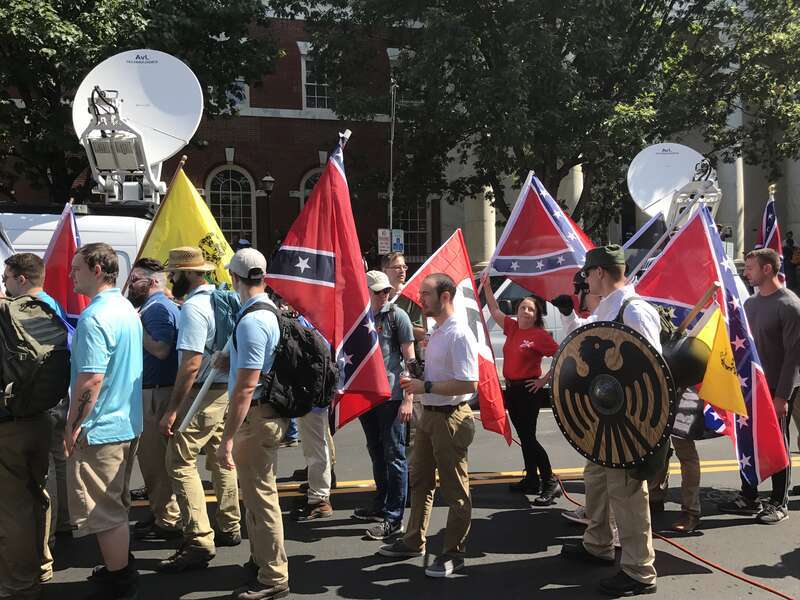 Alt-right members preparing to enter Emancipation Park holding Nazi, Confederate, and Gadsden "Don't Tread on Me" flags.