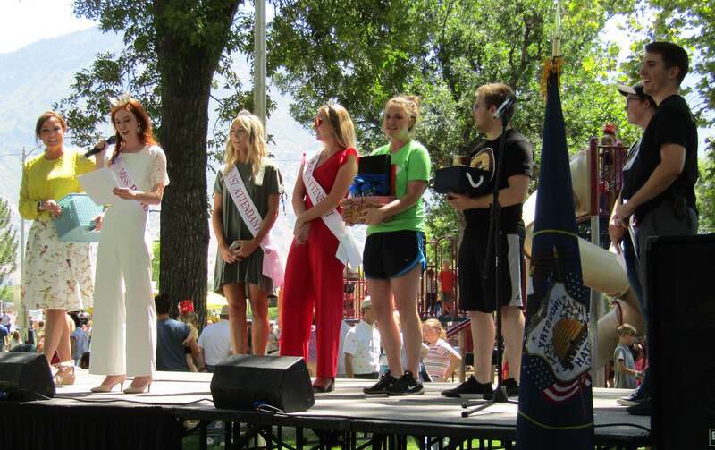 Miss Provo announces the winners of a pie contest in North Park, Provo on Pioneer Day. Also onstage is Provo Mayor Michelle Kaufusi.