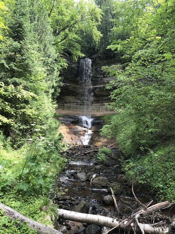 Munising Falls in summer. The waterfall is flowing but not at a high rate. Thick green trees frame the falls.
Munising Falls
Keywords: pictured rocks; waterfall; munising falls