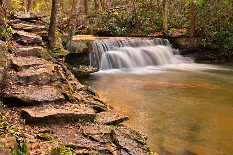Long exposure waterfall from Swallow Falls State Park in Maryland, USA. HDR composite from multiple exposures. 
For those who might want to use this photo for editorial purposes, please note the waterfall &amp; stepping stones face the opposite