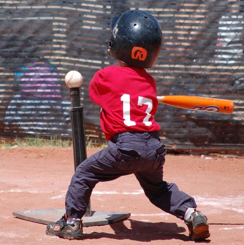 A right-handed tee ball player swings at a ball on the tee.  Photo taken by Vinnie Ahuja